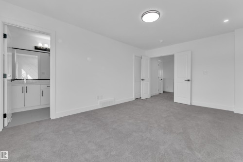 Plush gray carpeting, white walls, and a contemporary ceiling light fixture - 285 Munn Way, Leduc, AB 