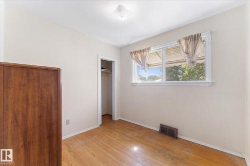 Wood-finish flooring with a closet and window - 9315 86 Street Nw, Edmonton, AB 