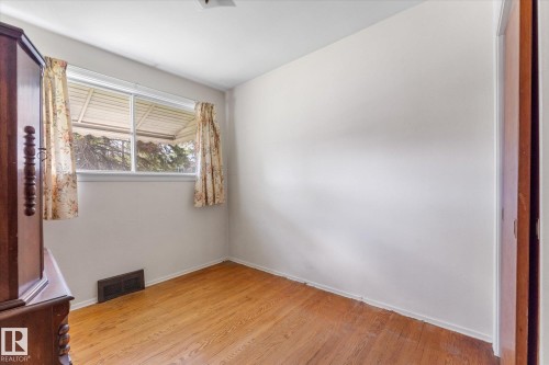 Wood-finish flooring with white walls and a white-framed window - 9315 86 Street Nw, Edmonton, AB 