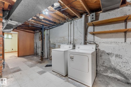 Laundry area with exposed joists, brick column, and built-in shelving - 9315 86 Street Nw, Edmonton, AB 