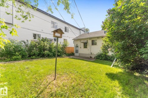 Expansive lawn area with mature perimeter landscaping and a concrete patio - 9315 86 Street Nw, Edmonton, AB 