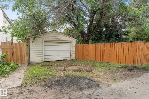 Detached garage with horizontal siding, a fenced perimeter, and a concrete pathway - 9315 86 Street Nw, Edmonton, AB 