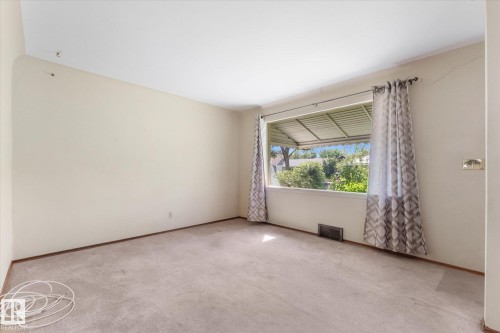 Carpeted flooring, neutral wall tones, and a large window with an exterior awning - 9315 86 Street Nw, Edmonton, AB 