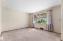 Carpeted flooring, neutral wall tones, and a large window with an exterior awning - 9315 86 Street Nw, Edmonton, AB 