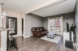 Spacious living area featuring wood-finish flooring and a sliding glass door to a private balcony - 