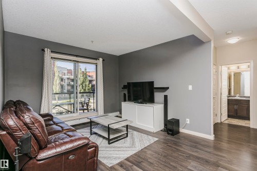 Dark wood-finish flooring throughout the living space - #217 304 Ambleside Link Sw, Edmonton, AB 