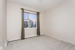 Carpeted flooring, neutral wall color, window with exterior building and tree scenery, baseboard heating elements - 