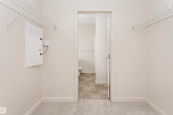 Carpeted flooring, white wire shelving, and a doorway leading to a room with tiled flooring - 
