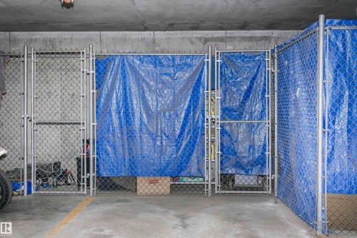 Chain-link storage cages with gated access within a concrete parking structure - #217 304 Ambleside Link Sw, Edmonton, AB 