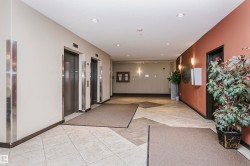 Tiled flooring, two passenger elevators, recessed ceiling lighting, and wall-mounted sconces - 