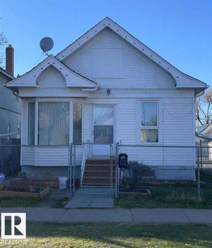 White siding exterior with a gabled roofline and decorative trim - 9332 106A Avenue Nw, Edmonton, AB 