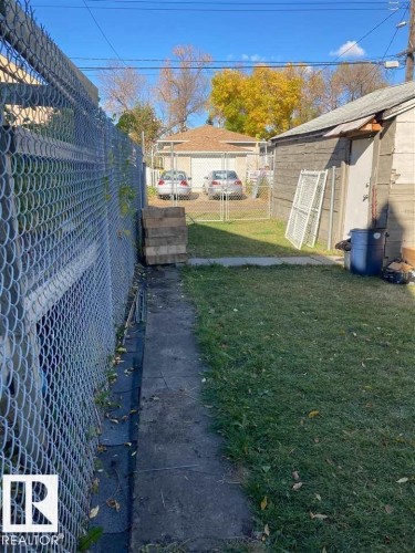 Chain link fencing with a concrete path and grassy area - 9332 106A Avenue Nw, Edmonton, AB 