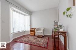 Bay window with vertical blinds, bright interior with light-toned walls, and wood-finish flooring - 