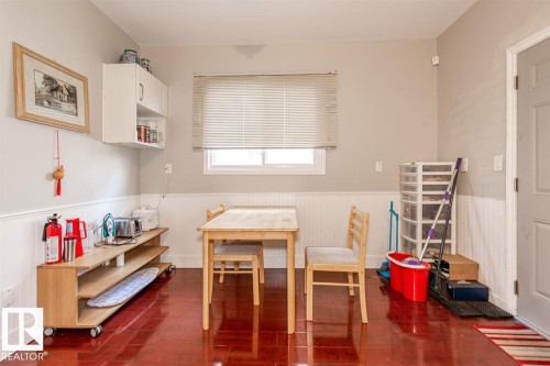 Wood-finish flooring with white wainscoting and neutral wall paint - 9332 106A Avenue Nw, Edmonton, AB 