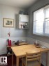 White beadboard wainscoting, wall-mounted white cabinetry, and a large window with blinds - 9332 106A Avenue Nw, Edmonton, AB 