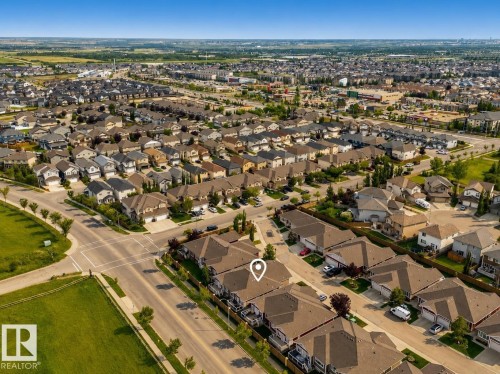 Aerial perspective of a developed residential community with extensive landscaping and nearby commercial establishments - #9 175 Mcconachie Dr Nw, Edmonton, AB 