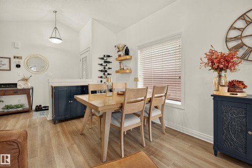 Vaulted ceiling with pendant lighting, wood-finish flooring, half wall, and built-in wine rack - #9 175 Mcconachie Dr Nw, Edmonton, AB 