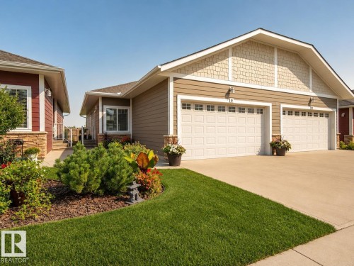 Two-car garage with panel-style doors and upper window inserts - #9 175 Mcconachie Dr Nw, Edmonton, AB 
