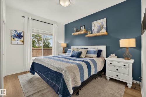 Wood-finish flooring, white trim, sliding glass window, recessed ceiling light, and a prominent accent wall - #9 175 Mcconachie Dr Nw, Edmonton, AB 