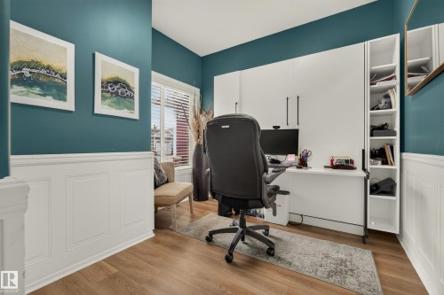 Wood-finish flooring, white wainscoting, and a window with blinds - #9 175 Mcconachie Dr Nw, Edmonton, AB 