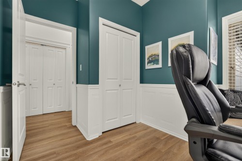Wood-finish flooring with wainscoting, bi-fold closet doors, and window with horizontal blinds - #9 175 Mcconachie Dr Nw, Edmonton, AB 