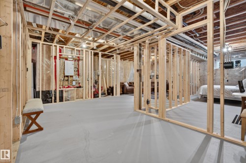 Unfinished basement with exposed ceiling joists, concrete flooring, and framed interior walls - #9 175 Mcconachie Dr Nw, Edmonton, AB 