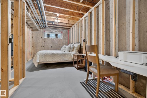 Unfinished basement framing with exposed ceiling joists, concrete foundation walls, and a window - #9 175 Mcconachie Dr Nw, Edmonton, AB 