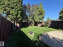 Fenced backyard featuring a manicured lawn, established trees, and a gravel area - 4708 117A Street Northwest, Edmonton, AB 