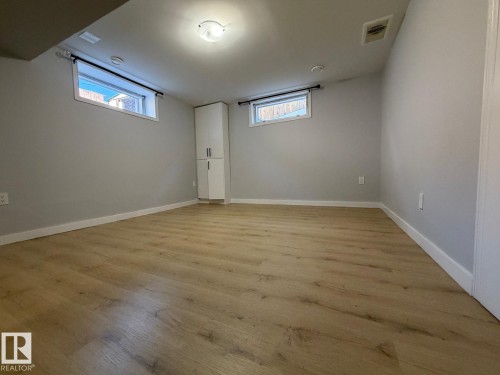 Wood-finish flooring, recessed windows, built-in storage cabinet, and ceiling-mounted lighting fixture - 4708 117A Street Northwest, Edmonton, AB 