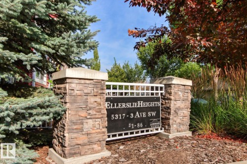 Stone-clad entry pillars with capstones frame a property sign and white lattice - 5319 3 Avenue Sw, Edmonton, AB 