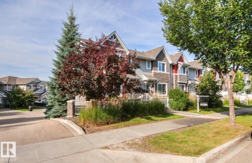 Townhouse exterior featuring gabled roofs, stone accents, and varied siding - 5319 3 Avenue Sw, Edmonton, AB 