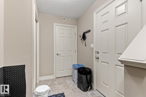Tiled flooring entry with multiple paneled doors and painted trim - 5319 3 Avenue Sw, Edmonton, AB 