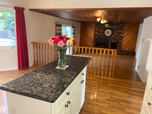 Central kitchen island with a dark speckled countertop - 4027 74 Street Nw, Edmonton, AB 