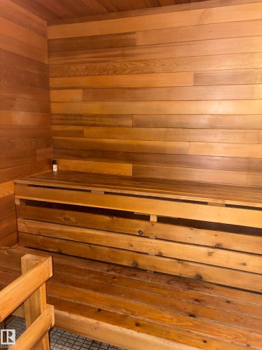 Wood-paneled room featuring built-in wooden benches and tiled flooring - 4027 74 Street Nw, Edmonton, AB 