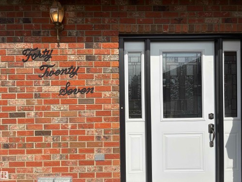 Brick exterior with a decorative wall-mounted light fixture - 4027 74 Street Nw, Edmonton, AB 