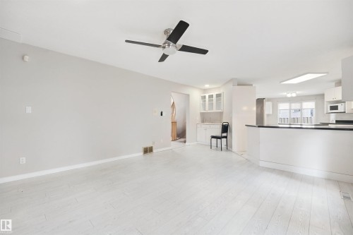 Light wood-finish flooring, recessed lighting, and a ceiling fan - 5107 17 Avenue Nw, Edmonton, AB 