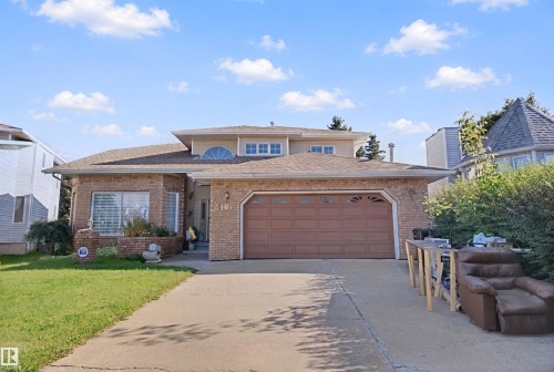 Brick exterior with an integrated two-car garage, concrete driveway, and established landscaping - 5107 17 Avenue Nw, Edmonton, AB 
