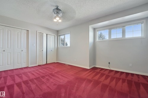 Recessed window with multiple panes, two sets of bi-fold closet doors, secondary window, and ceiling fan with integrated lighting - 5107 17 Avenue Nw, Edmonton, AB 