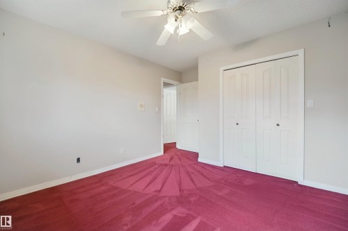 White walls, red carpeting, and a ceiling fan with integrated lighting - 5107 17 Avenue Nw, Edmonton, AB 