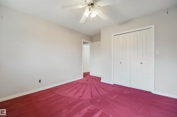 White walls, red carpeting, and a ceiling fan with integrated lighting - 