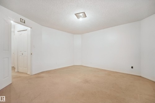 Neutral wall tones, recessed lighting fixture, textured ceiling, and carpeted flooring - 5107 17 Avenue Nw, Edmonton, AB 