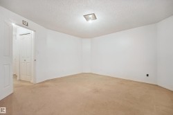 Neutral wall tones, recessed lighting fixture, textured ceiling, and carpeted flooring - 
