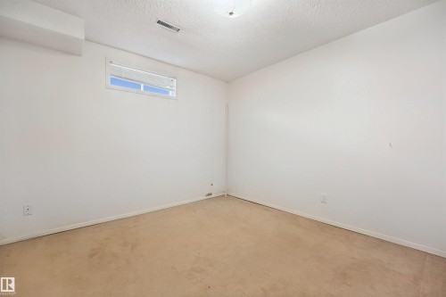 Carpeted flooring, white painted walls, and a single window with horizontal blinds - 5107 17 Avenue Nw, Edmonton, AB 