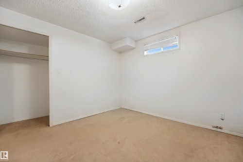 Wall-to-wall carpeting, built-in open closet, and window with blinds - 5107 17 Avenue Nw, Edmonton, AB 