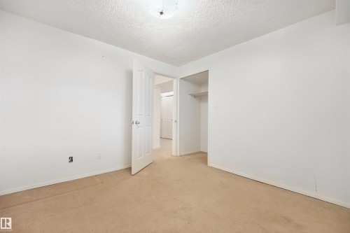 Neutral-toned carpet flooring with white painted walls and ceiling - 5107 17 Avenue Nw, Edmonton, AB 