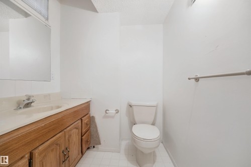 Wood-finish vanity with an integrated sink and chrome faucet - 5107 17 Avenue Nw, Edmonton, AB 