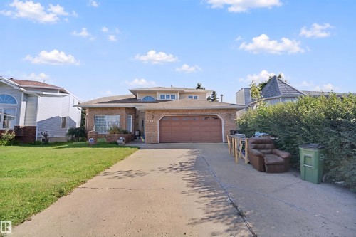 Brick exterior with a large front window, an attached garage, and a concrete driveway - 5107 17 Avenue Nw, Edmonton, AB 