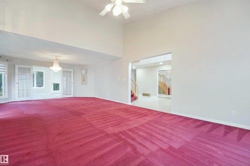 Vaulted ceiling with ceiling fan, archway entry, and white double-pane windows with horizontal blinds - 5107 17 Avenue Nw, Edmonton, AB 