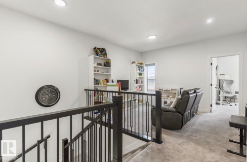 Loft area featuring carpeting, recessed lighting, white walls, and a black metal stair railing - 19703 29 Avenue Nw, Edmonton, AB 
