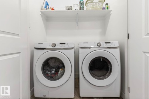 Laundry area with a built-in shelf and wood-finish flooring - 19703 29 Avenue Nw, Edmonton, AB 